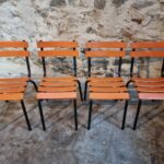 Vintage French industrial school chairs from the 1960s with orange metal slats and black tubular steel frames